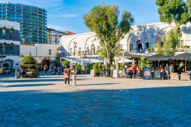 GIBRALTAR, İngiltere - 10 Mart 2023: Turistler Gibraltar kasabasındaki Casemates Meydanı 'nda güneşli havanın tadını çıkarıyorlar. Cebelitarık bir İngiliz Denizaşırı Toprakları ve popüler bir turizm beldesidir.
