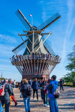 LISSE, HOLLLLAND - 19 Nisan 2023: Ziyaretçiler, dünyanın en büyük çiçek bahçelerinden biri olan Keukenhof Park 'ta güneşli bir günün ve dünya çapında popüler bir turistik merkezin keyfini çıkarıyorlar..