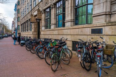 AMSTERDAM, HOLLAND - 18 Nisan 2023: Amsterdam 'da bir caddeye park edilmiş bisikletler. Bisiklet, yaklaşık 515 km (320 mil) adanmış bisiklet şeritleri olan başkentte çok popüler bir seyahat biçimidir.