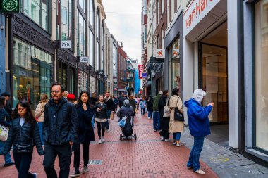AMSTERDAM, HOLLAND - 18 Nisan 2023: Amsterdam 'ın Baraj Meydanı' ndan Muntplein Meydanı 'na kadar uzanan en işlek alışveriş caddesi Kalverstraat Caddesi' ndeki müşteriler