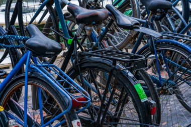 AMSTERDAM, HOLLAND - 18 Nisan 2023: Amsterdam 'da bir kaldırıma parkedilmiş bisikletler. Bisiklet, yaklaşık 515 km (320 mil) adanmış bisiklet şeritleri olan başkentte çok popüler bir seyahat biçimidir.