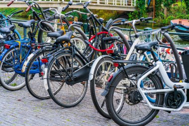AMSTERDAM, HOLLAND - 18 Nisan 2023: Amsterdam 'da bir kaldırıma parkedilmiş bisikletler. Bisiklet, yaklaşık 515 km (320 mil) adanmış bisiklet şeritleri olan başkentte çok popüler bir seyahat biçimidir.