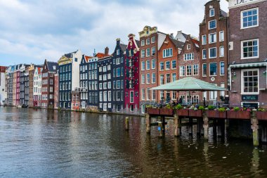 AMSTERDAM, HOLLAND - 18 Nisan 2023: Hollanda başkentinde sanatsal mirası, ayrıntılı kanal sistemi ve dar cepheli evleri ile bilinen bir kanal hattı