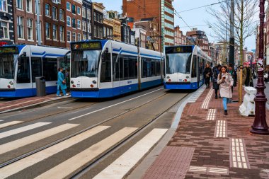 AMSTERDAM, HOLLLAND - 18 Nisan 2023: Amsterdam sokak manzarası, ayrıntılı kanal sistemi, dar evler ve şehir çevresinde sayısız bisiklet yolu ile bilinen canlı Hollanda başkenti