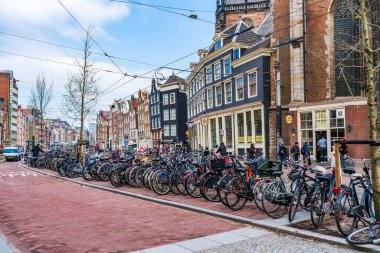 AMSTERDAM, HOLLAND - 18 Nisan 2023: Amsterdam 'da bir caddeye park edilmiş bisikletler. Bisiklet, yaklaşık 515 km (320 mil) adanmış bisiklet şeritleri olan başkentte çok popüler bir seyahat biçimidir.