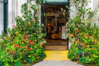 LONDON, İngiltere - 24 Mayıs 2023: Londra 'daki Bloom yıllık çiçek sergisi sırasında Chelsea' de bir mağazanın vitrinini muhteşem bir çiçek sergisi dekore etti