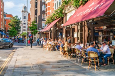 Londra, İngiltere - 24 Mayıs 2023: İnsanlar, şık butikler ve King 's Road' da kuyruk oluşturan lüks restoranlarla bilinen Chelsea 'de güneşli bir bahar gününün tadını çıkarıyorlar.