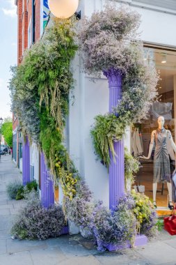 LONDON, İngiltere - 24 Mayıs 2023: Londra 'daki Bloom yıllık çiçek sergisi sırasında Chelsea' de bir mağazanın vitrinini muhteşem bir çiçek sergisi dekore etti