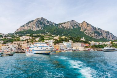 CAPRI, İtalya - SEPTEMBER 19, 2023: Capri Adası 'ndaki Marina Grande tekneleri engebeli manzarası, lüks otelleri ve lüks tasarımcı alışverişleriyle ünlüdür. Yazın Capri 'nin dramatik kıyı şeridi birçok yat çeker.