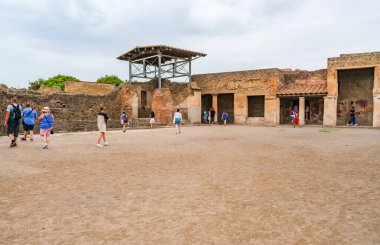 POMPEI, İtalya - 20 Eylül 2023: Turistler Vezüv Dağı 'nın 79 yılındaki patlaması sonucu gömülü antik bir şehir olan Pompei kalıntılarını ziyaret ettiler. Pompei harabeleri UNESCO Dünya Mirası Alanlarının bir parçası.