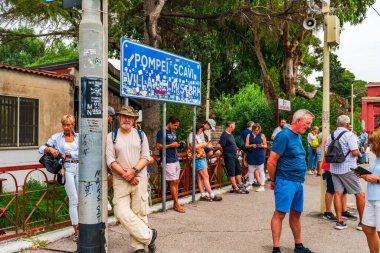 POMPEI, İtalya - 20 Eylül 2023: Turistler Pompei Scavi istasyonunda tren bekliyor. Pompei, M.S. 79 yılında Vesuvius volkanı tarafından yok edilen antik bir Roma şehridir.
