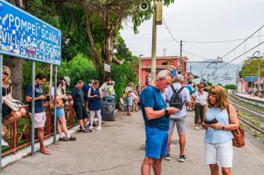 POMPEI, İtalya - 20 Eylül 2023: Turistler Pompei Scavi istasyonunda tren bekliyor. Pompei, M.S. 79 yılında Vesuvius volkanı tarafından yok edilen antik bir Roma şehridir.