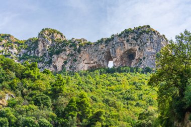 Positano 'nun üzerinde kemerleri olan kayalıklar - İtalya' nın Campania kentindeki Amalfi kıyısında pitoresk bir köy.