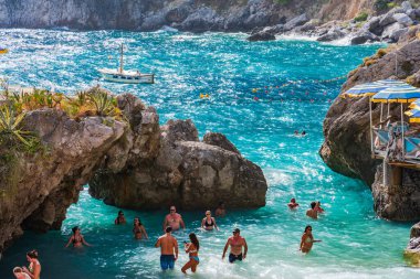 CAPRI, İtalya - 22 EPTEMBER 2023: Capri Adası 'ndaki Marina Piccola' da tatilciler, engebeli manzarası, lüks otelleri ve lüks tasarımcı alışverişleriyle ünlü