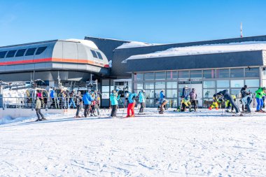 KRONPLATZ, İtalya - 21 Ocak 2024: İtalya 'da popüler bir kış sporları merkezi olan Kronplatz' daki bir dağın tepesinde kayakçılar ve snowboardcular.