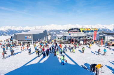 KRONPLATZ, İtalya - 21 Ocak 2024: İtalya 'da popüler bir kış sporları merkezi olan Kronplatz' daki bir dağın tepesinde kayakçılar ve snowboardcular.