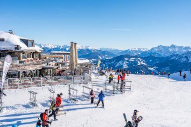 KRONPLATZ, İtalya - 21 Ocak 2024: İtalya 'da popüler bir kış sporları merkezi olan Kronplatz' daki bir dağın tepesinde kayakçılar ve snowboardcular.