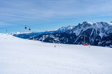 KRONPLATZ, İtalya - 21 Ocak 2024: İtalya 'da popüler bir kış sporları merkezi olan Kronplatz' daki bir dağın tepesinde kayakçılar ve snowboardcular.