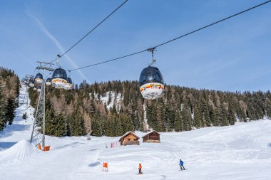 KRONPLATZ, ITALY - 21 Ocak 2024: Kablolu araçlar kayakçıları ve snowboardcuları İtalya 'da popüler bir kış sporları merkezi olan Kronplatz' daki dağın tepesine çıkarıyor.