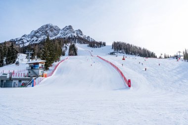 KRONPLATZ, İtalya - 21 Ocak 2024: İtalya 'da popüler bir kış sporları merkezi olan Kronplatz' daki bir dağın tepesinde kayakçılar ve snowboardcular.