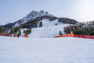 KRONPLATZ, İtalya - 21 Ocak 2024: İtalya 'da popüler bir kış sporları merkezi olan Kronplatz' daki bir dağın tepesinde kayakçılar ve snowboardcular.