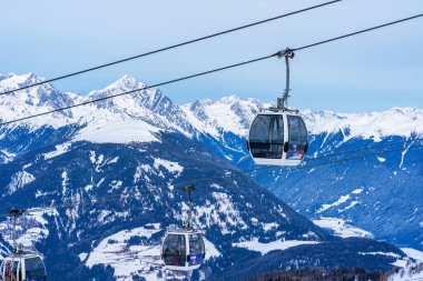 KRONPLATZ, ITALY - 26 Ocak 2024: Kablolu araçlar, İtalya 'da popüler bir kış sporları merkezi olan Kronplatz' daki bir dağın tepesine kayakçıları ve snowboardcuları çıkarıyor.