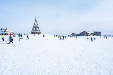 KRONPLATZ, İtalya - 21 Ocak 2024: İtalya 'da popüler bir kış sporları merkezi olan Kronplatz' daki bir dağın tepesinde kayakçılar ve snowboardcular.