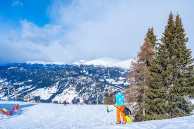 KRONPLATZ, İtalya - 23 Ocak 2024: İtalya 'da popüler bir kış sporları merkezi olan Kronplatz' daki bir dağın tepesinde kayakçılar ve snowboardcular.