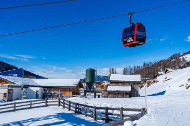 KRONPLATZ, İtalya - 24 Ocak 2024: Cable car, İtalya 'da popüler bir kış sporları merkezi olan Kronplatz' daki bir dağın tepesinde kayakçıları ve snowboardcuları alır.