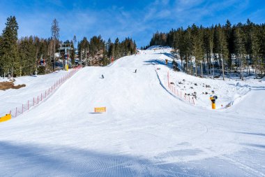 KRONPLATZ, İtalya - 26 Ocak 2024: İtalya 'da popüler bir kış sporları merkezi olan Kronplatz' daki bir dağın tepesinde kayakçılar ve snowboardcular.