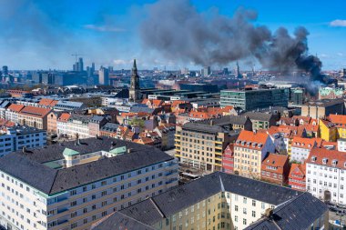 COPENHAGEN, DENMARK - 16 Nisan 2024: Kopenhag 'ın merkezinde tarihi Kopenhag Borsası Salı sabahı alevler içinde yanarken kara duman sürükleniyor.