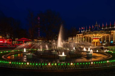 COPENHAGEN, DENMARK - 15 Nisan 2024: Kopenhag 'daki Tivoli Bahçeleri, antik hız treni ve canlı eğlence programı ile dünyanın ikinci en eski, 19. yüzyıl eğlence parkı..