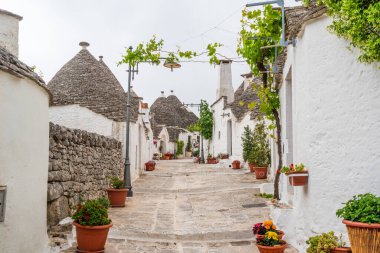 ALBEROBELLO, İtalya - 16 Mayıs 2024: Alberobello konik çatıları olan eski kuru taş trulli evleri ile ünlüdür. Alberobello 'nun tarihi merkezi UNESCO tarafından dünya mirası olarak ilan edildi..