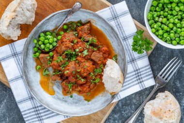 Kırmızı şarap ve domates soslu haşlanmış biftek güveci.