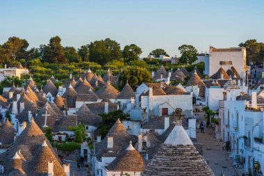 ALBEROBELLO, İtalya - 17 Mayıs 2024: Alberobello 'da konik çatıları olan ünlü eski kuru taş trulli evleri görmek. Alberobello 'nun tarihi merkezi UNESCO tarafından dünya mirası olarak ilan edildi..