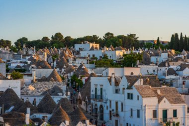 ALBEROBELLO, İtalya - 17 Mayıs 2024: Alberobello 'da konik çatıları olan ünlü eski kuru taş trulli evleri görmek. Alberobello 'nun tarihi merkezi UNESCO tarafından dünya mirası olarak ilan edildi..