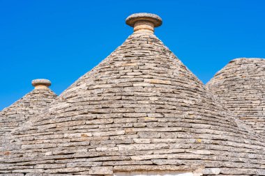 Alberobello 'daki ünlü kuru taş trulli evlerin konik çatıları. İtalya