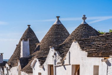 Alberobello 'daki ünlü kuru taş trulli evlerin konik çatıları. İtalya