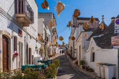 ALBEROBELLO, İtalya - 17 Mayıs 2024: Alberobello Puglia bölgesinde eski kuru taş trulli evleriyle ünlü küçük bir kasabadır. Alberobello 'nun tarihi merkezi UNESCO tarafından dünya mirası olarak ilan edildi.
