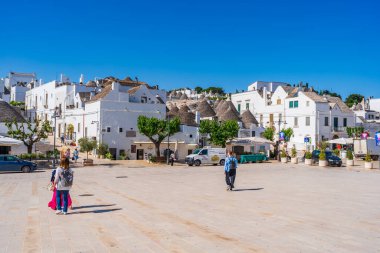 ALBEROBELLO, İtalya - 17 Mayıs 2024: Alberobello Puglia bölgesinde eski kuru taş trulli evleriyle ünlü küçük bir kasabadır. Alberobello 'nun tarihi merkezi UNESCO tarafından dünya mirası olarak ilan edildi.
