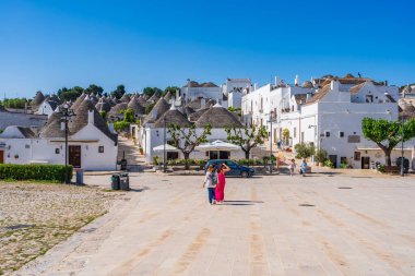 ALBEROBELLO, İtalya - 17 Mayıs 2024: Alberobello Puglia bölgesinde eski kuru taş trulli evleriyle ünlü küçük bir kasabadır. Alberobello 'nun tarihi merkezi UNESCO tarafından dünya mirası olarak ilan edildi.