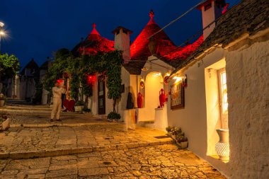 ALBEROBELLO, İtalya - 16 Mayıs 2024: Alberobello 'da konik çatıları olan ünlü eski kuru taş trulli evleri görmek. Alberobello 'nun tarihi merkezi UNESCO tarafından dünya mirası olarak ilan edildi..