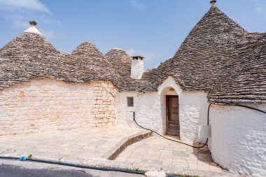 İtalya, Alberobello 'da konik çatıları olan ünlü tarihi kuru taş trulli evler..