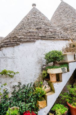 İtalya, Alberobello 'da konik çatıları olan ünlü tarihi kuru taş trulli evler..