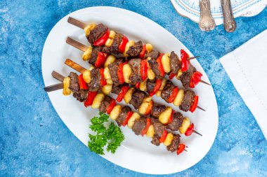 Izgara gnocchi, biftek ve kırmızı biber şişleri.