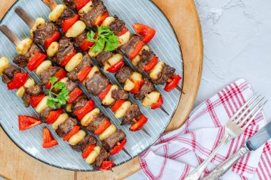 Izgara gnocchi, biftek ve kırmızı biber şişleri.