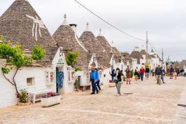 ALBEROBELLO, İtalya - 16 Mayıs 2024: İtalya 'nın Puglia bölgesindeki küçük bir İtalyan kasabası olan Alberobello' da turist gezisi. Alberobello 'nun tarihi merkezi UNESCO tarafından dünya mirası olarak ilan edildi.