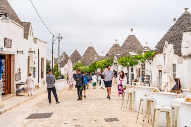 ALBEROBELLO, İtalya - 16 Mayıs 2024: İtalya 'nın Puglia bölgesindeki küçük bir İtalyan kasabası olan Alberobello' da turist gezisi. Alberobello 'nun tarihi merkezi UNESCO tarafından dünya mirası olarak ilan edildi.