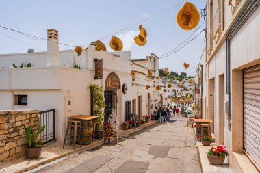 ALBEROBELLO, İtalya - 16 Mayıs 2024: İtalya 'nın Puglia bölgesindeki küçük bir İtalyan kasabası olan Alberobello' da turist gezisi. Alberobello 'nun tarihi merkezi UNESCO tarafından dünya mirası olarak ilan edildi.