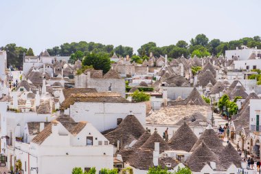 ALBEROBELLO, İtalya - 16 Mayıs 2024: Güney İtalya 'nın Puglia bölgesinde küçük bir İtalyan kasabası olan Alberobello' nun manzarası. Alberobello 'nun tarihi merkezi UNESCO tarafından dünya mirası olarak ilan edildi..